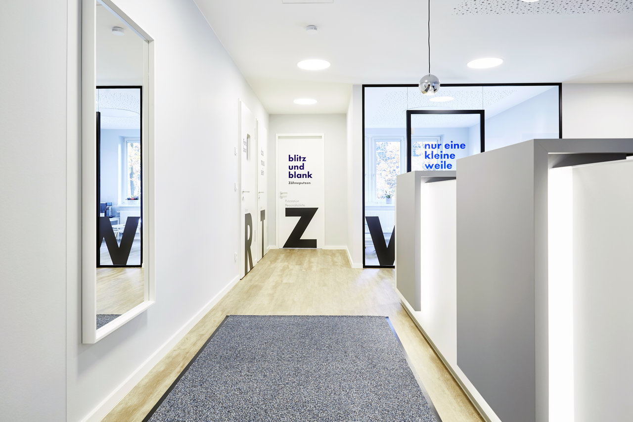 Der Eingangsbereich. Blick am Tresen entlang auf Toilette, Zahnputzecke, Röntgenraum und Wartebereich.